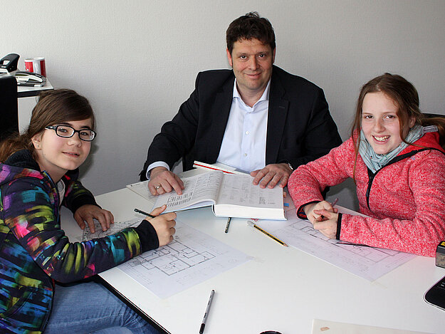 Diplom-Ingenieur Arne Schreier zeigte den Schülerinnen Kayla (rechts) und Anna bei der GWH Bauprojekte, welche Ausstattungen üblicherweise in Grundrissen abgebildet werden.